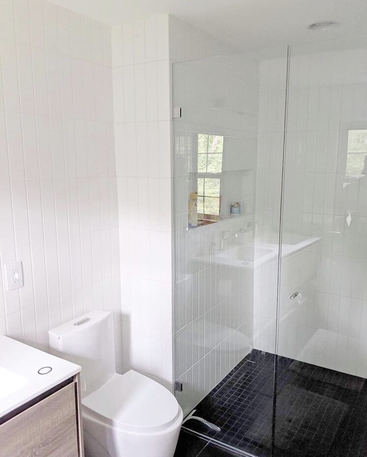 Bathroom with frameless glass shower and dark tile floor