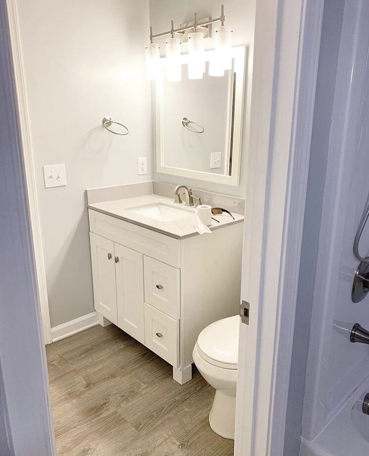 Half bath with white vanity and wood-look floor