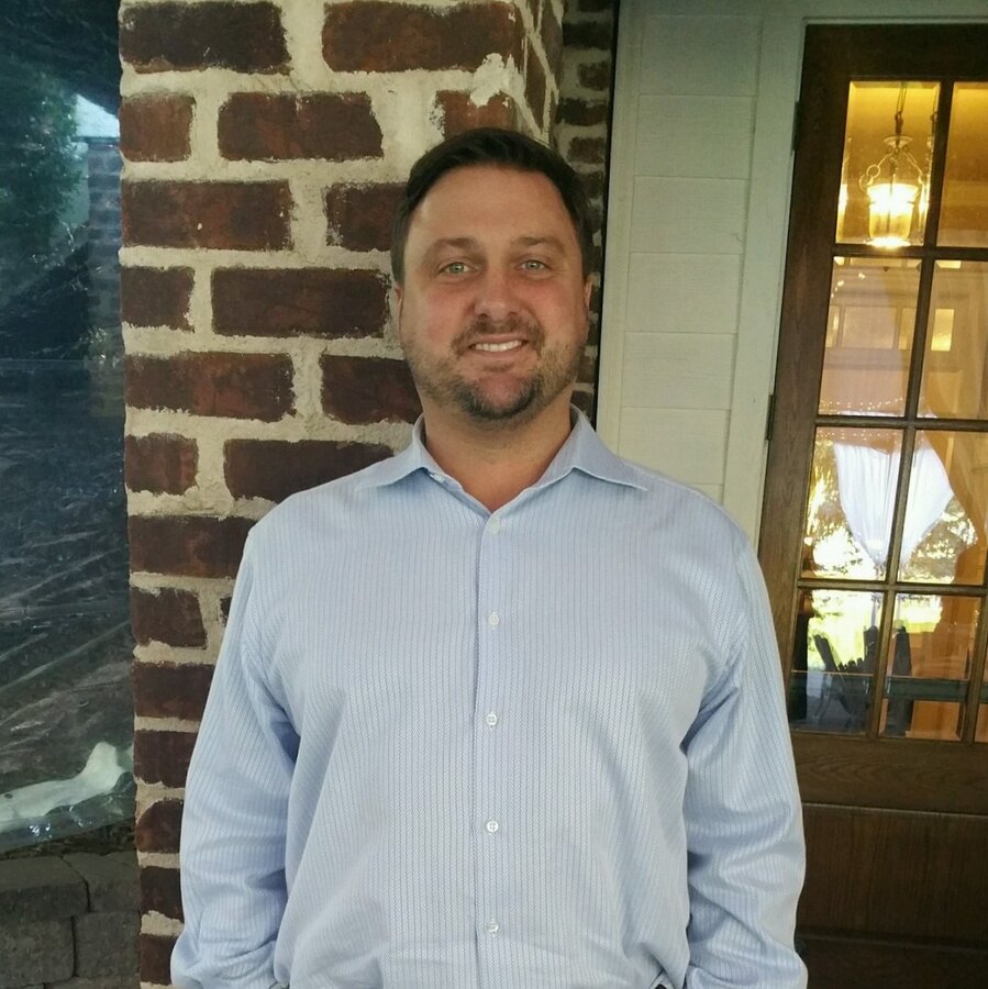 Robert 'Bob' Coffin, Owner and CEO of Robert Paul Contracting, standing on a brick porch
