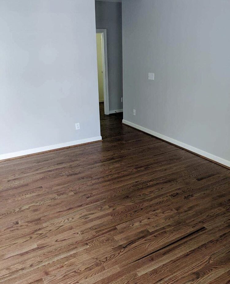 Empty room with refinished dark hardwood floors