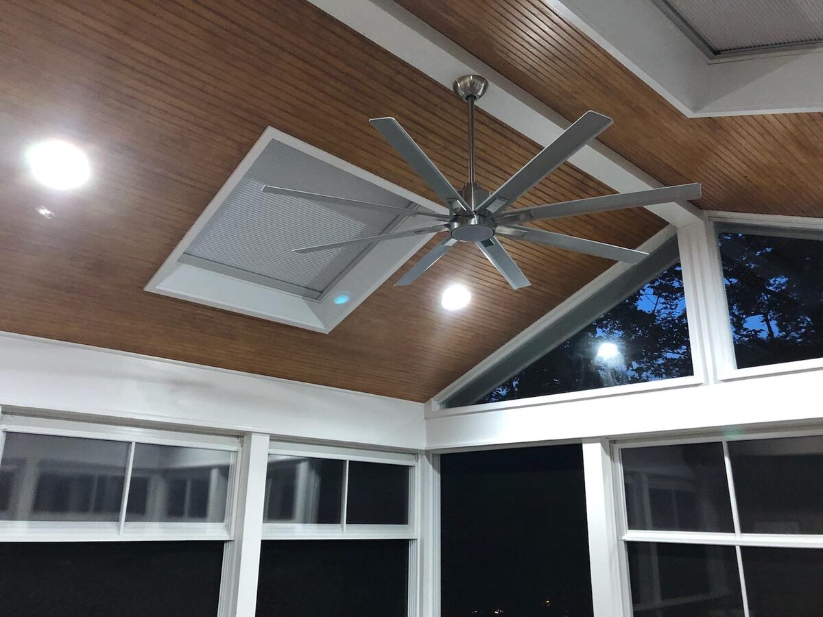 Wood porch ceiling with ceiling fan and skylights