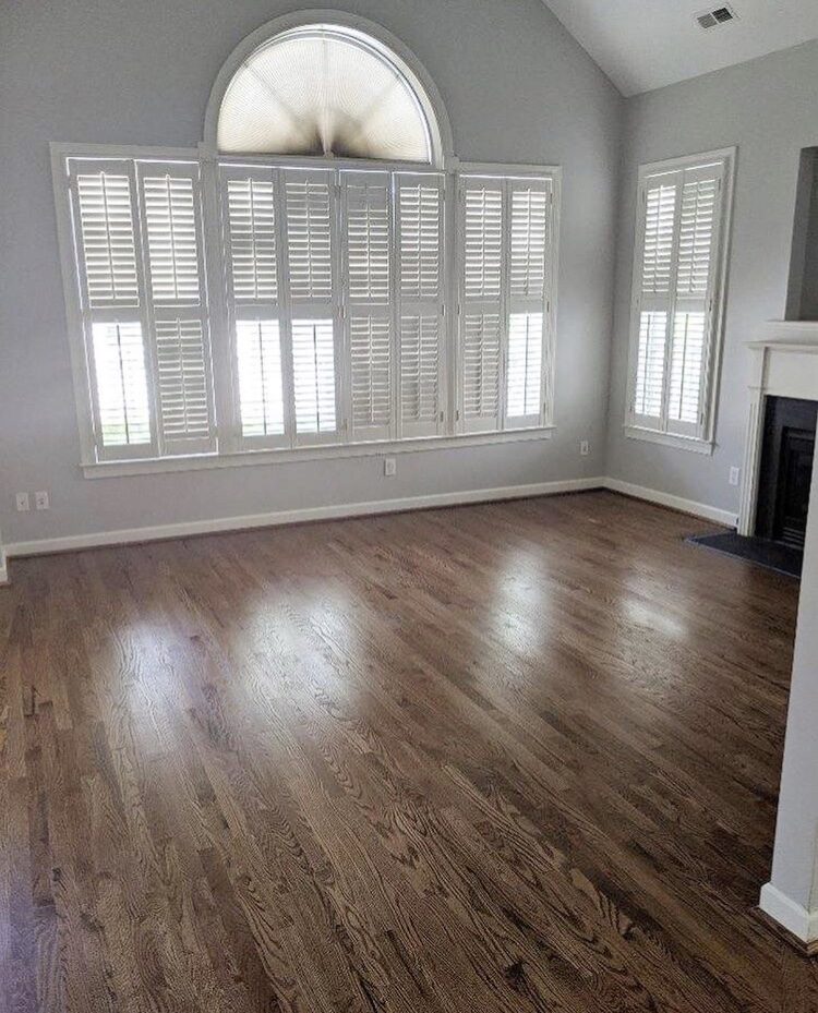 Living room with arched window, shutters and hardwood floors