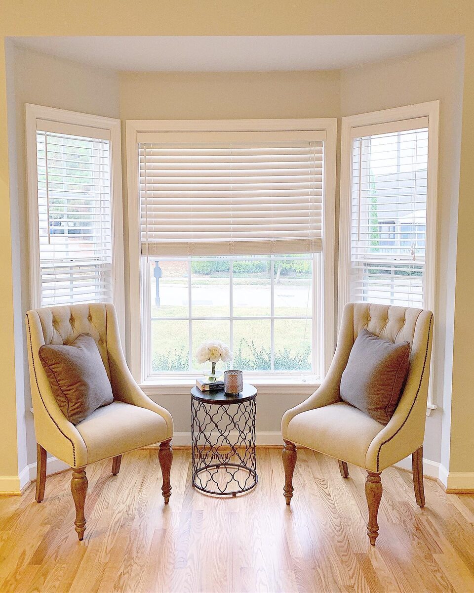 Bay window sitting area with two armchairs and hardwood floor
